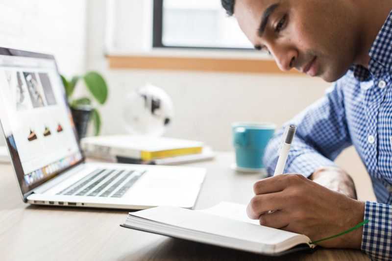 man working alone with laptop and notebook