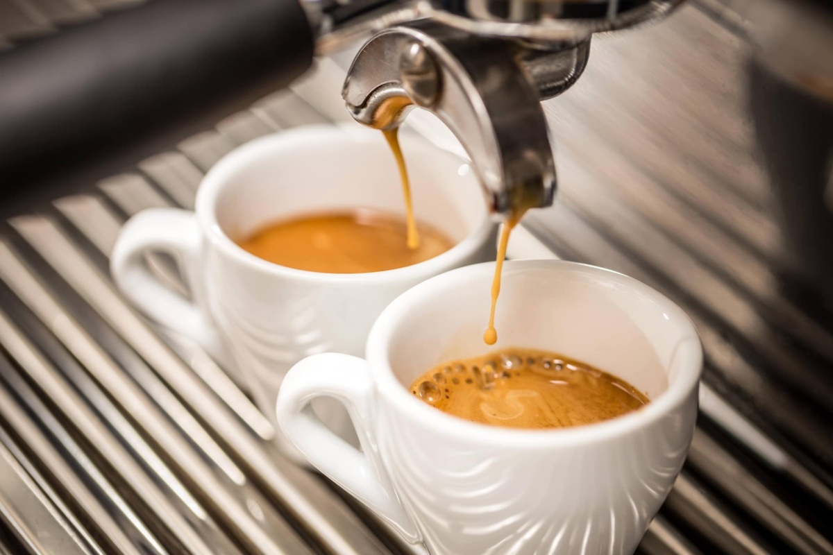 Espresso machine pouring coffee in white cups
