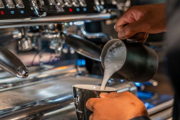 La Spaziale S10 2 Group Compact - barista pouring steamed milk