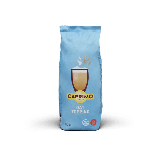 A blue 500g bag of Caprimo Oat Topping powder, featuring a graphic of a foamed oat drink on the front and vegan and plant‑based icons at the bottom, photographed against a white background.