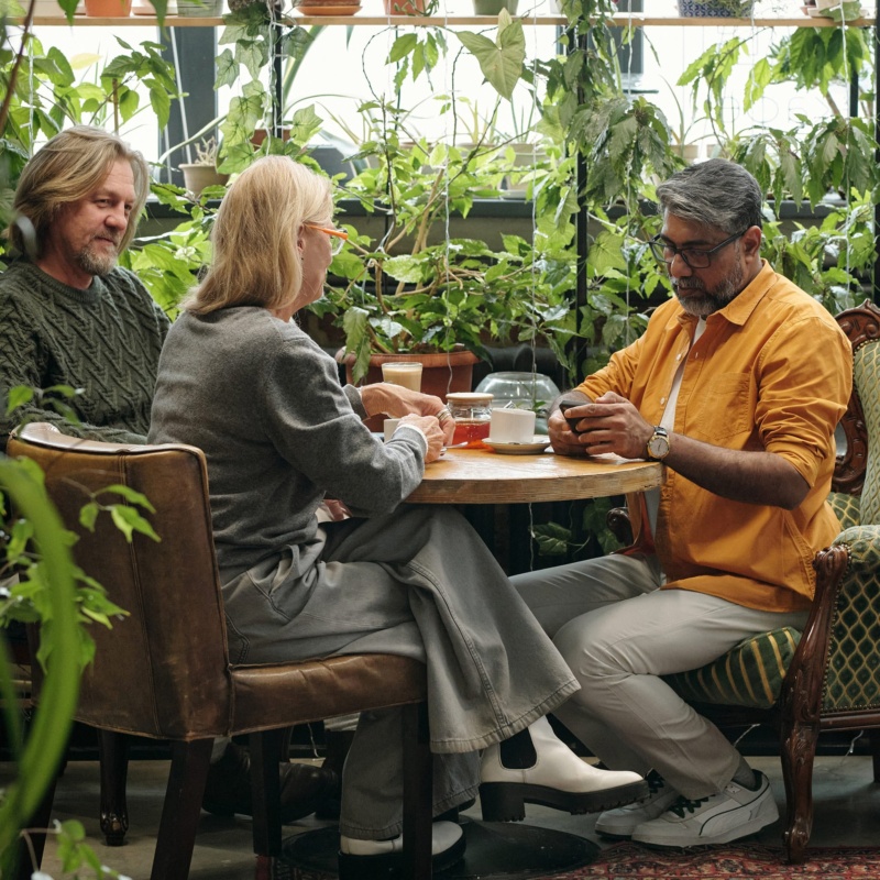 Friends enjoying hot drinks in garden centre