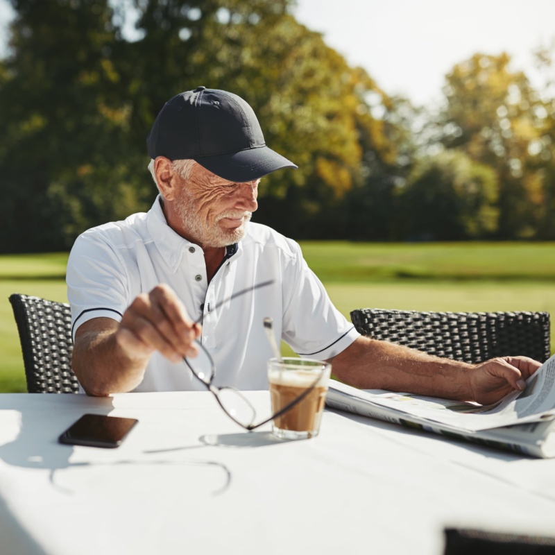 Golfer enjoying coffee outside at table