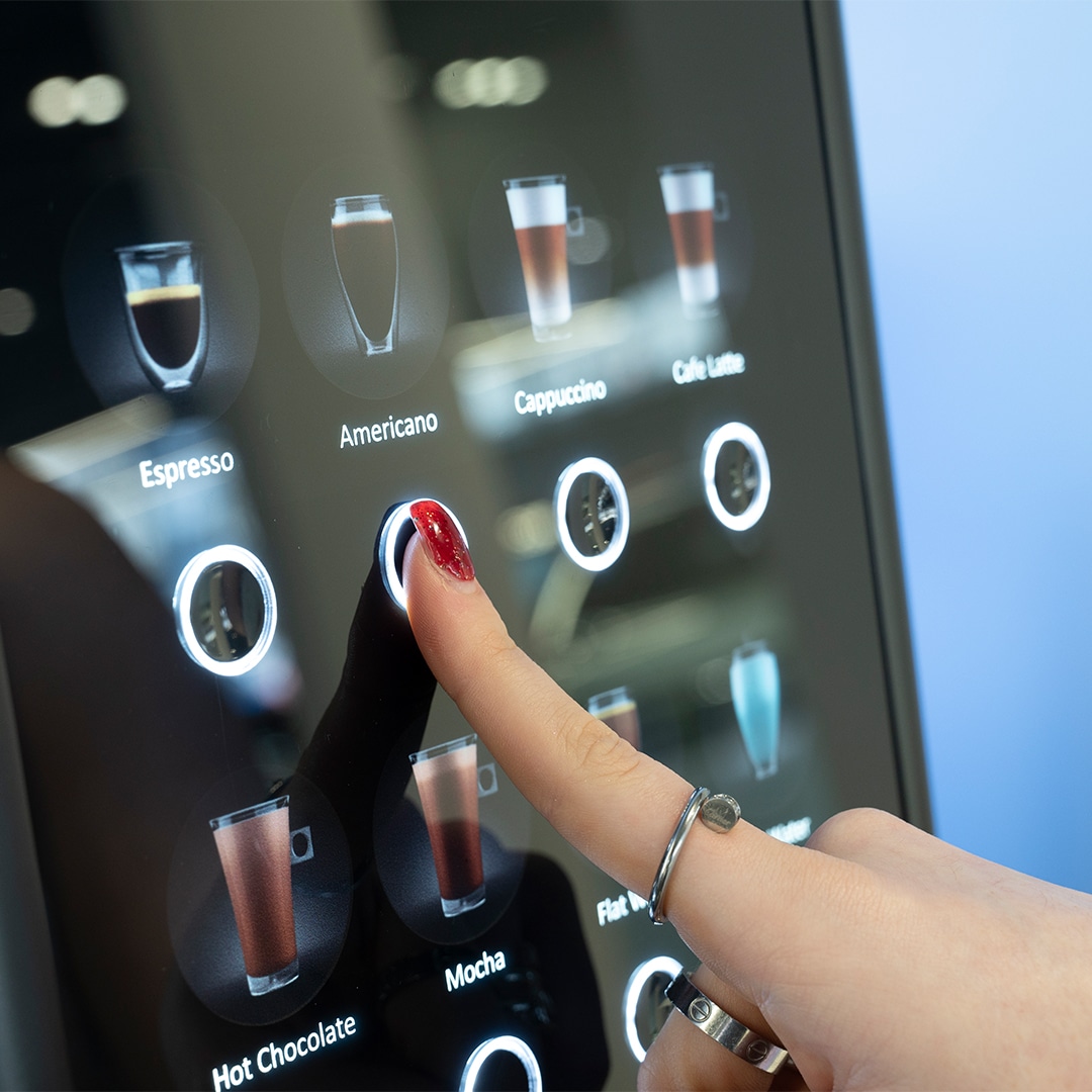 Finger pressing button on operated vending machine