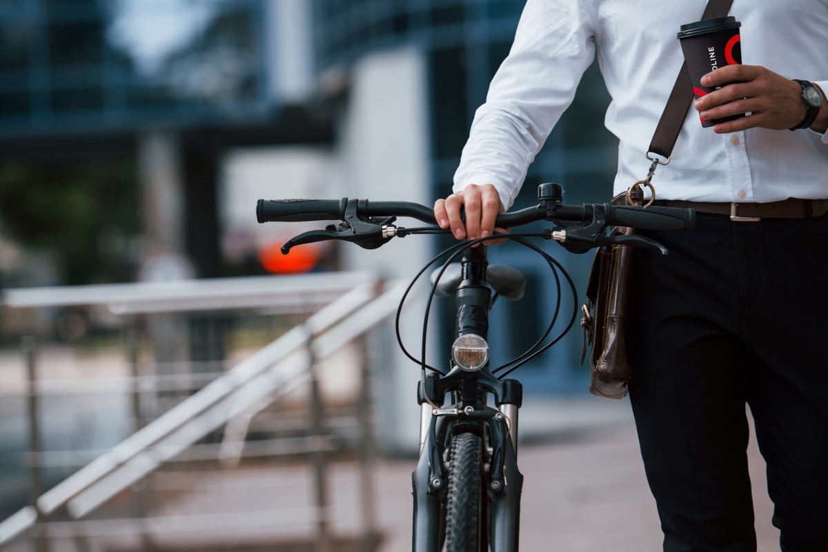 commuter pushing bike with liquidline coffee cup in hand