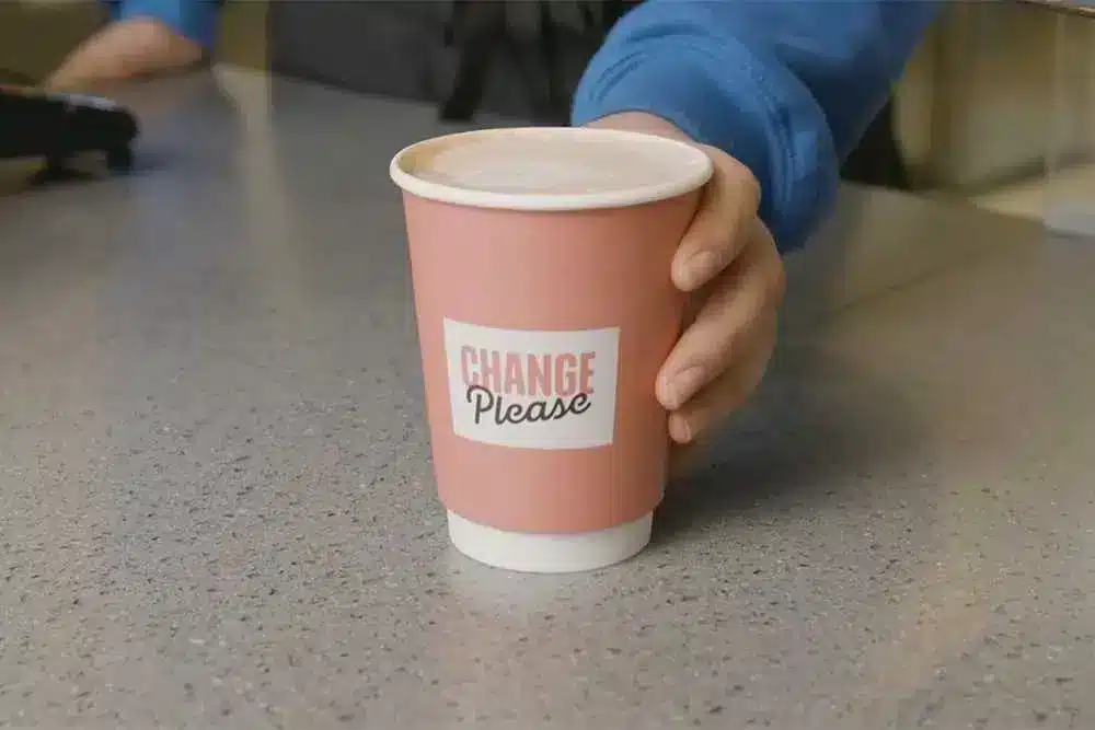 Change Please branded coffee cup