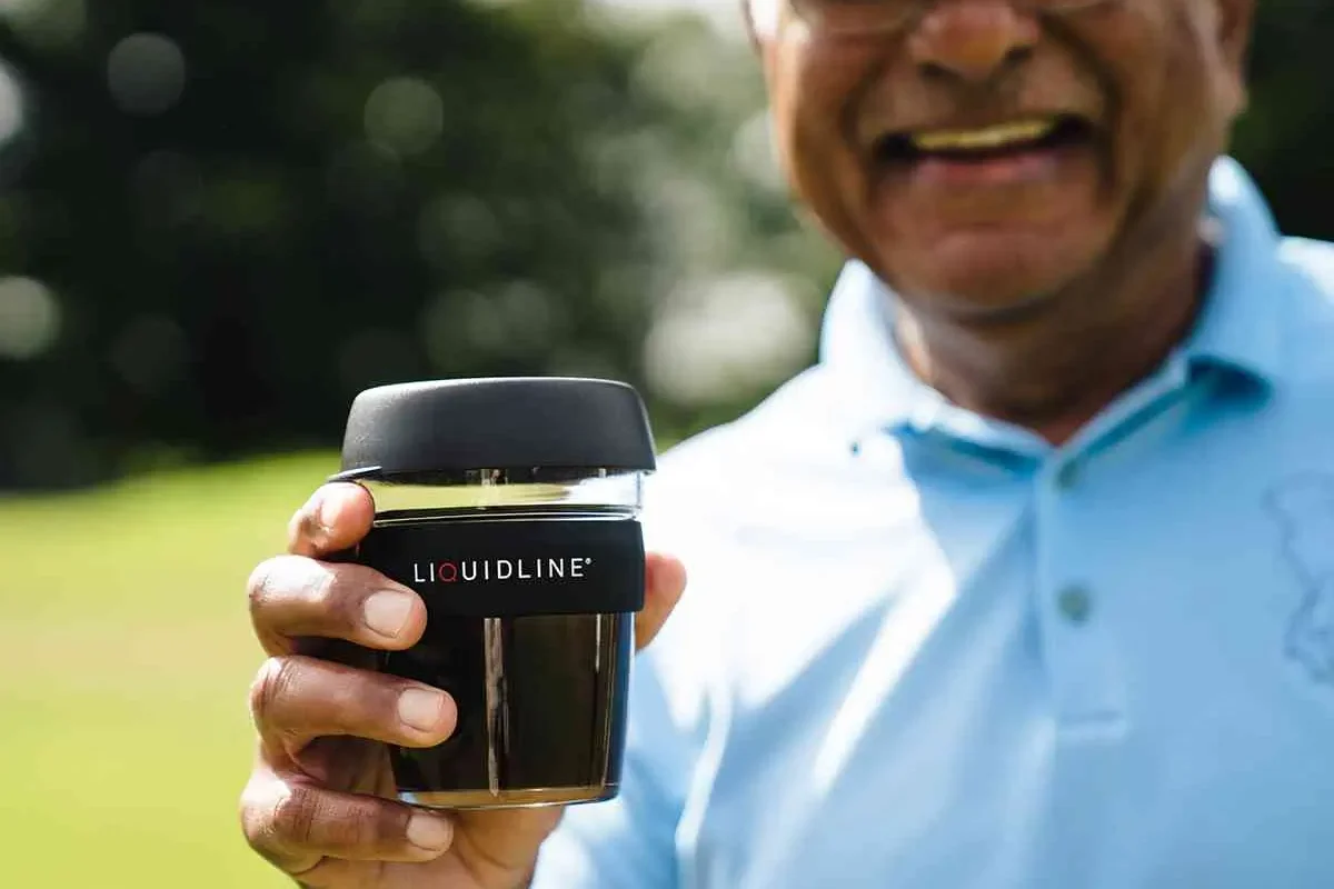 Golfer holding Liquidline coffee cup