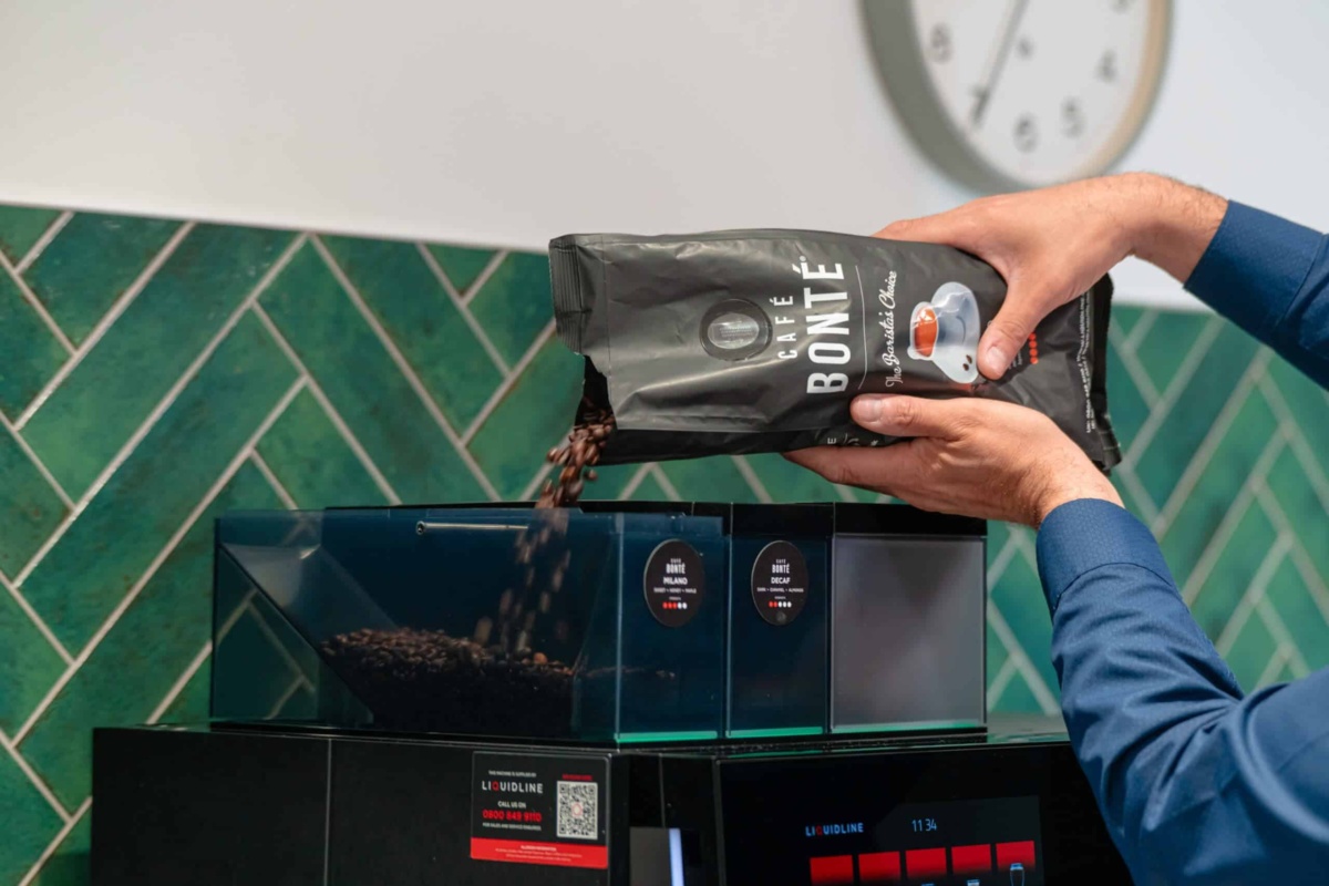 Coffee beans being poured into coffee machine
