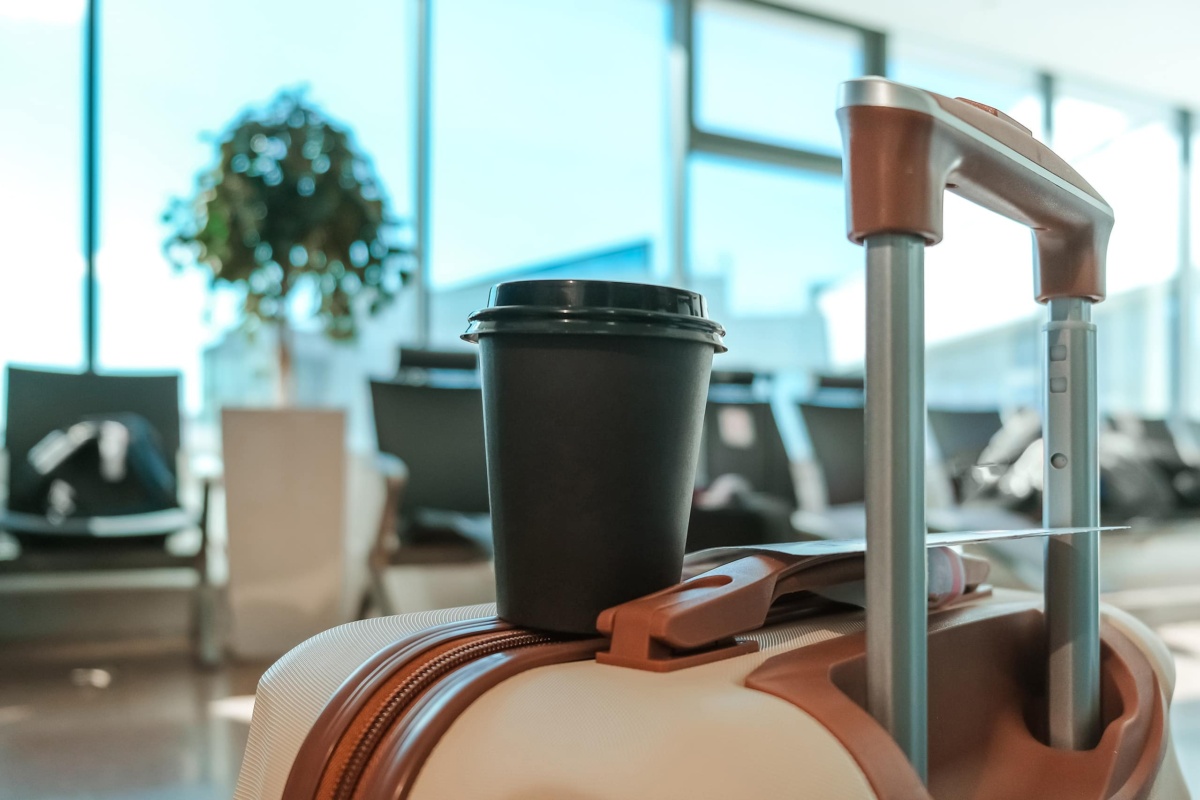Coffee cup on luggage in airport lounge