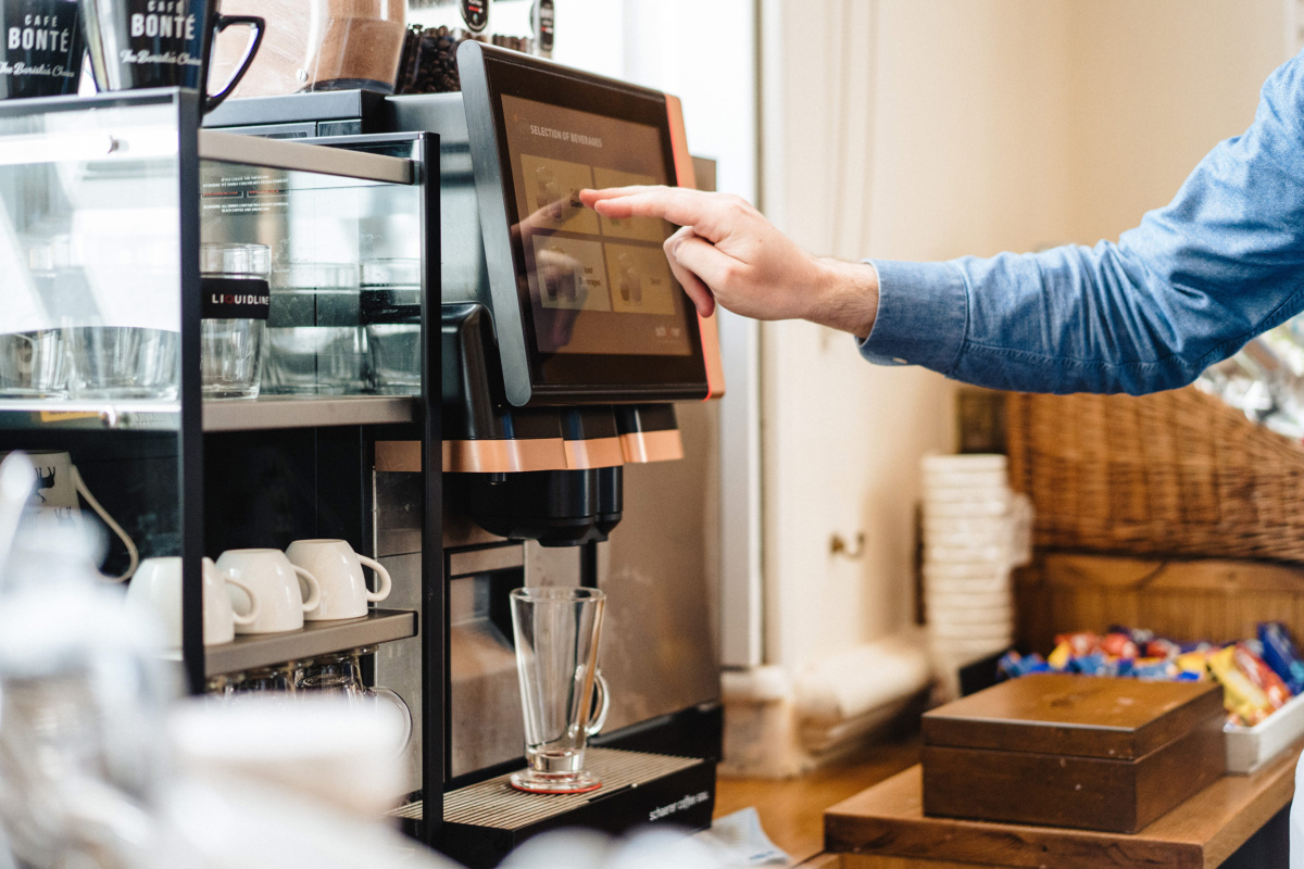 person using a bean to cup coffee machine