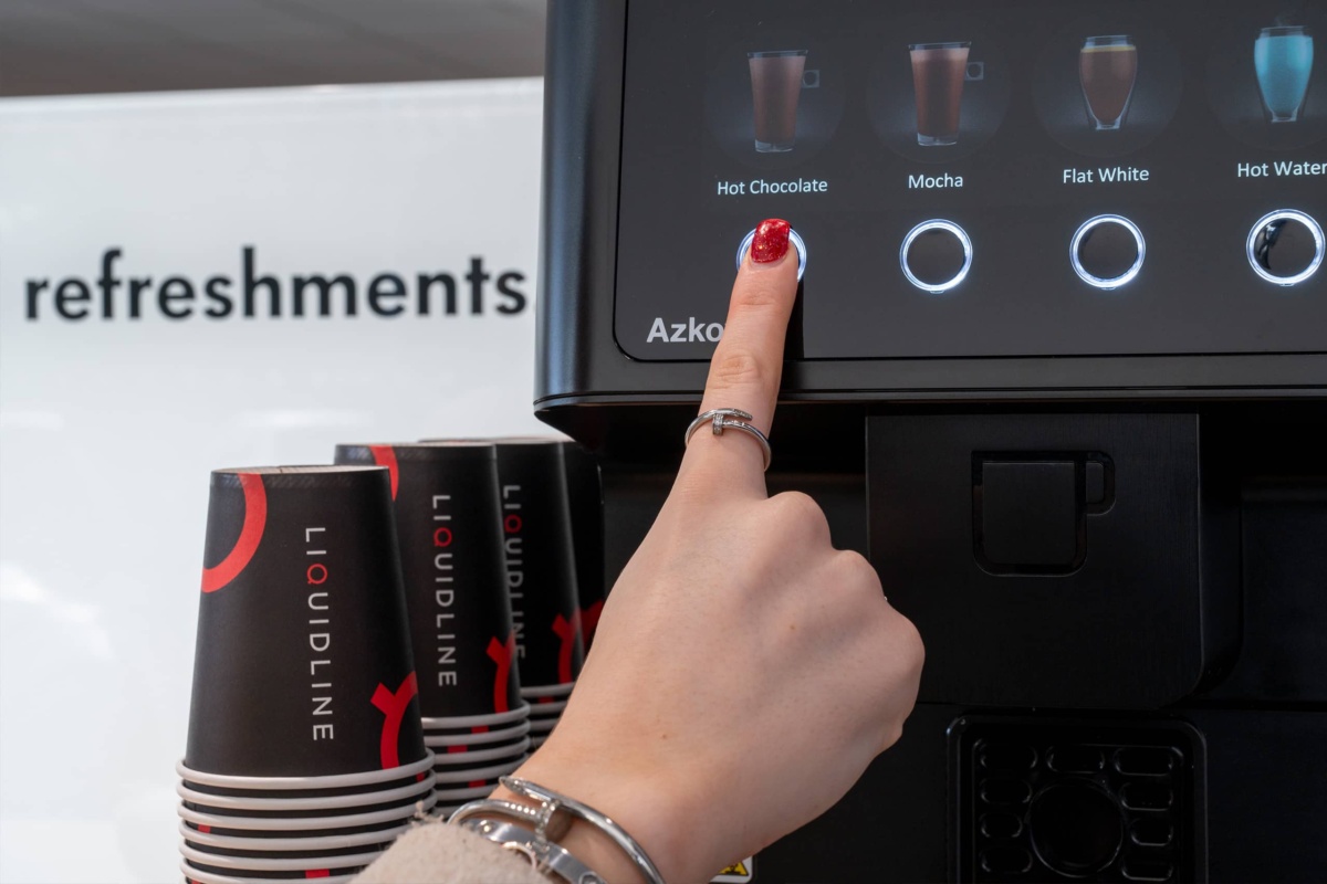 person selecting hot chocolate on a vending machine