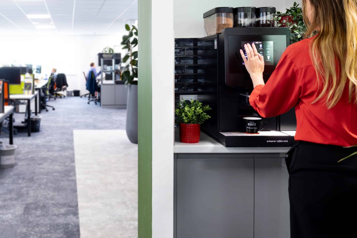 office worker using a bean to cup coffee machine