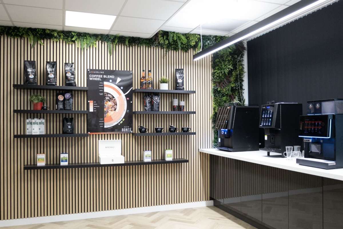 image if a wall with coffee cups, coffee bean bags and coffee syrups on selves