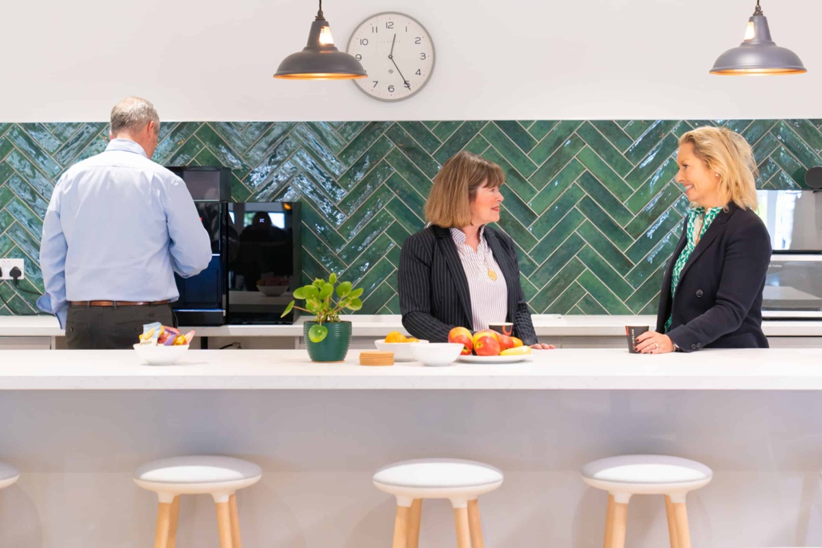 People in kitchen using coffee machine