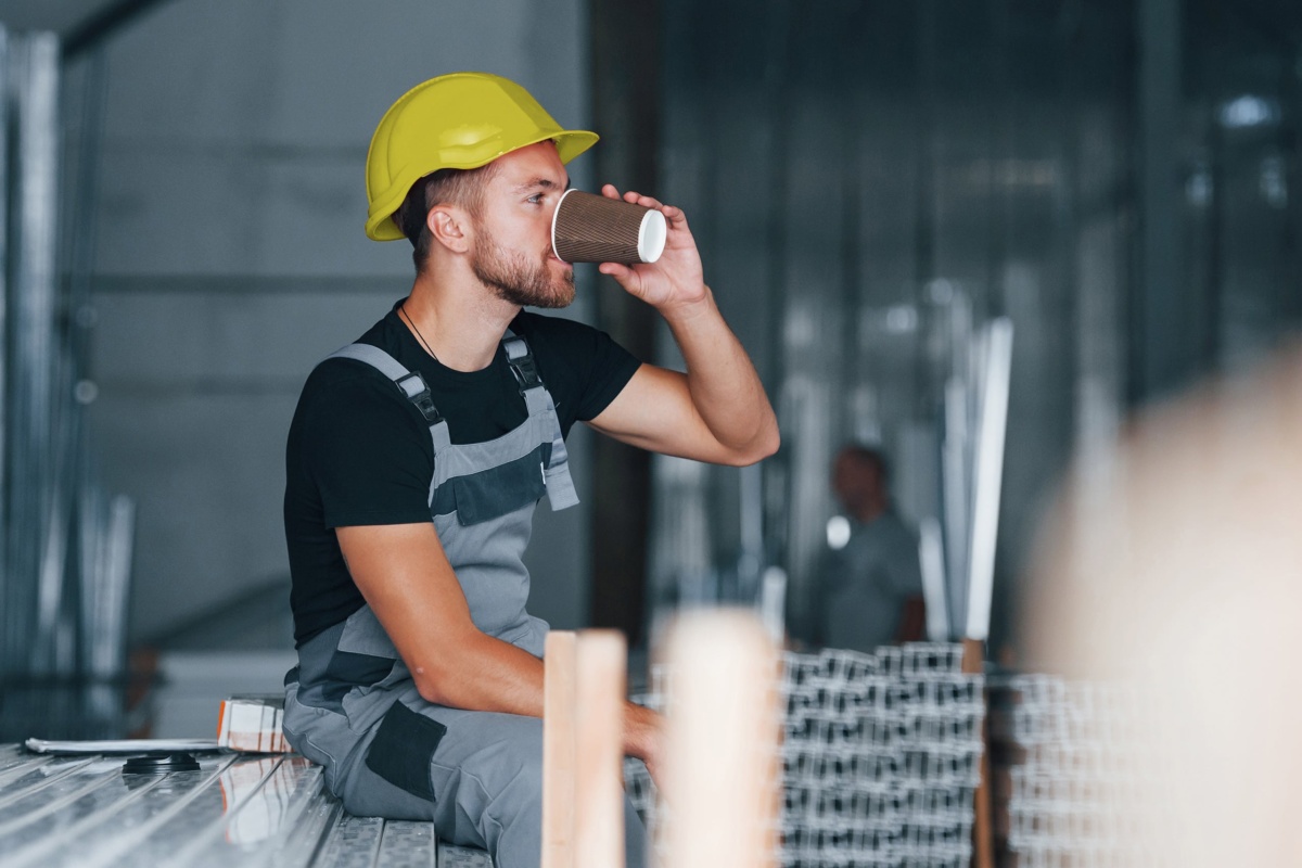 Trade workman drinking coffee from paper cup