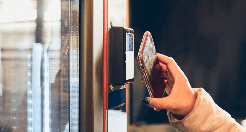 User presenting phone to pay on a touch less Gusto 6 Vending machine