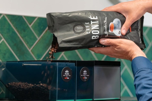 K2 fresh milk machine, hand pouring Cafe Bonte beans into hopper