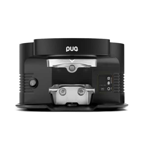 Front view of a black PUQPress M5 automatic coffee tamper, featuring a central metal tamping head, side power button, and a digital control panel on the right.