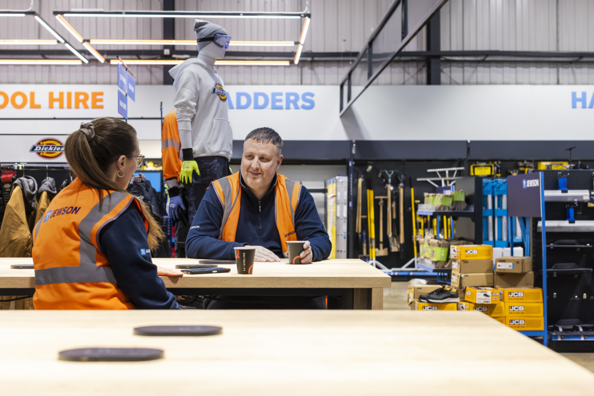 two people sat down having a coffee together at work
