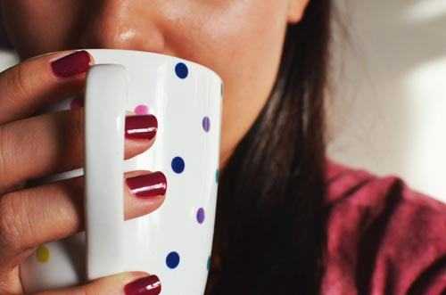 woman drinking from spotty mug