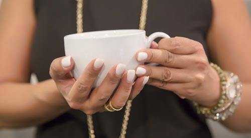 woman holding white coffee mug