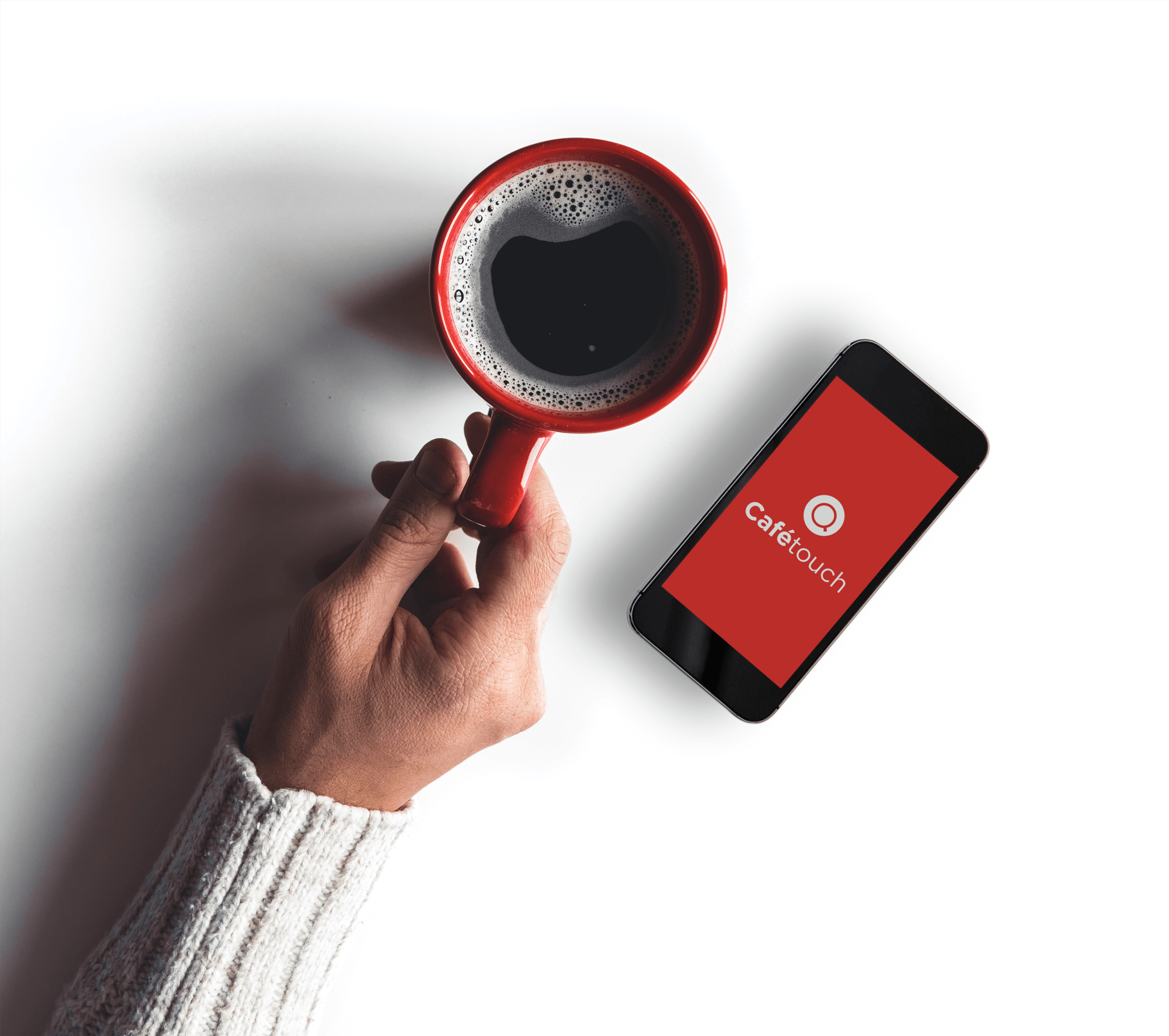 Hand holding red mug of black coffee with mobile phone to the right showing the cafetouch app