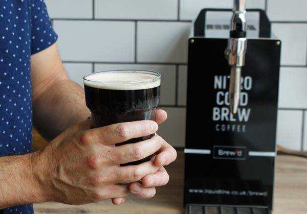 man holding a nitro cold brew pint