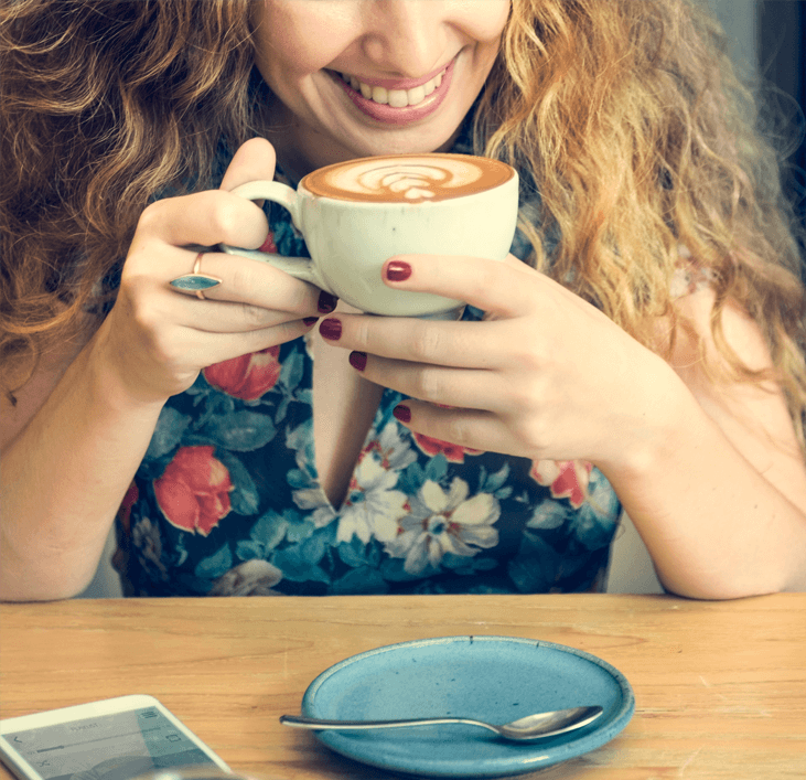 Woman enjoying a cappuccino coffee