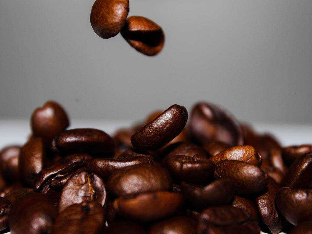 dark roasted coffee beans falling