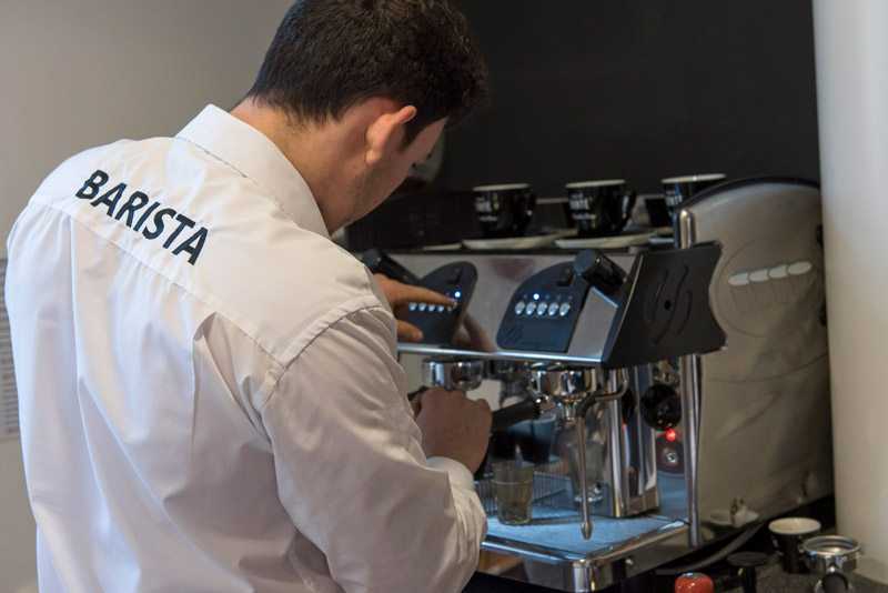 barista using traditional espresso machine