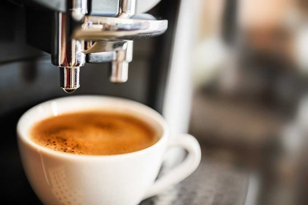 Commercial coffee machine dispensing an espresso