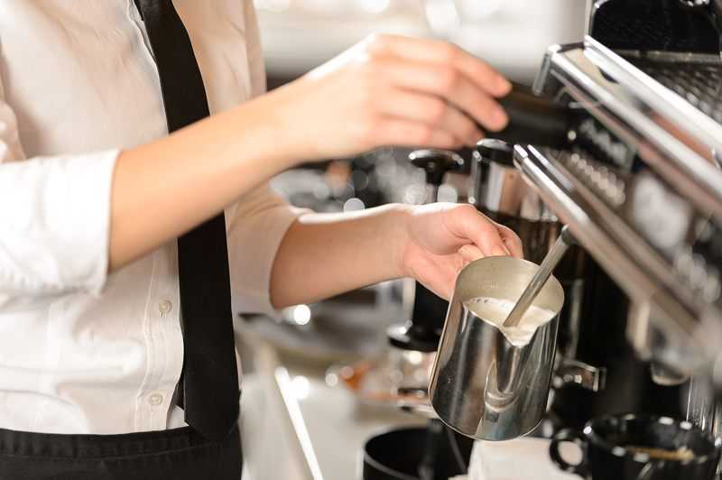 barista-frothing-milk-using-steam-wand barista frothing milk using a steam wand on traditional espresso machine