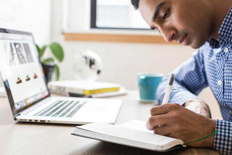 man working alone with laptop and notebook