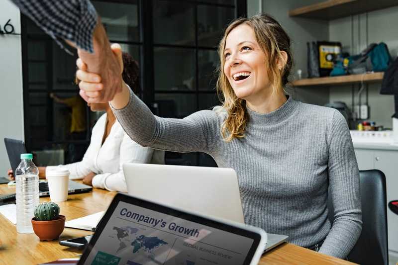 woman laughing and shaking hands