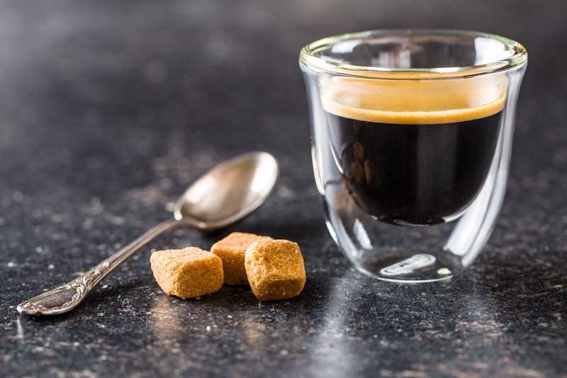 cup of espresso coffee with cinnamon, sugar and coffee beans
