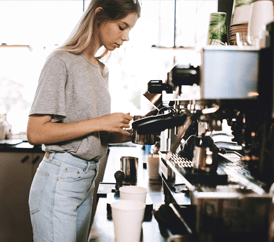 Woman making coffee in a coffee shop
