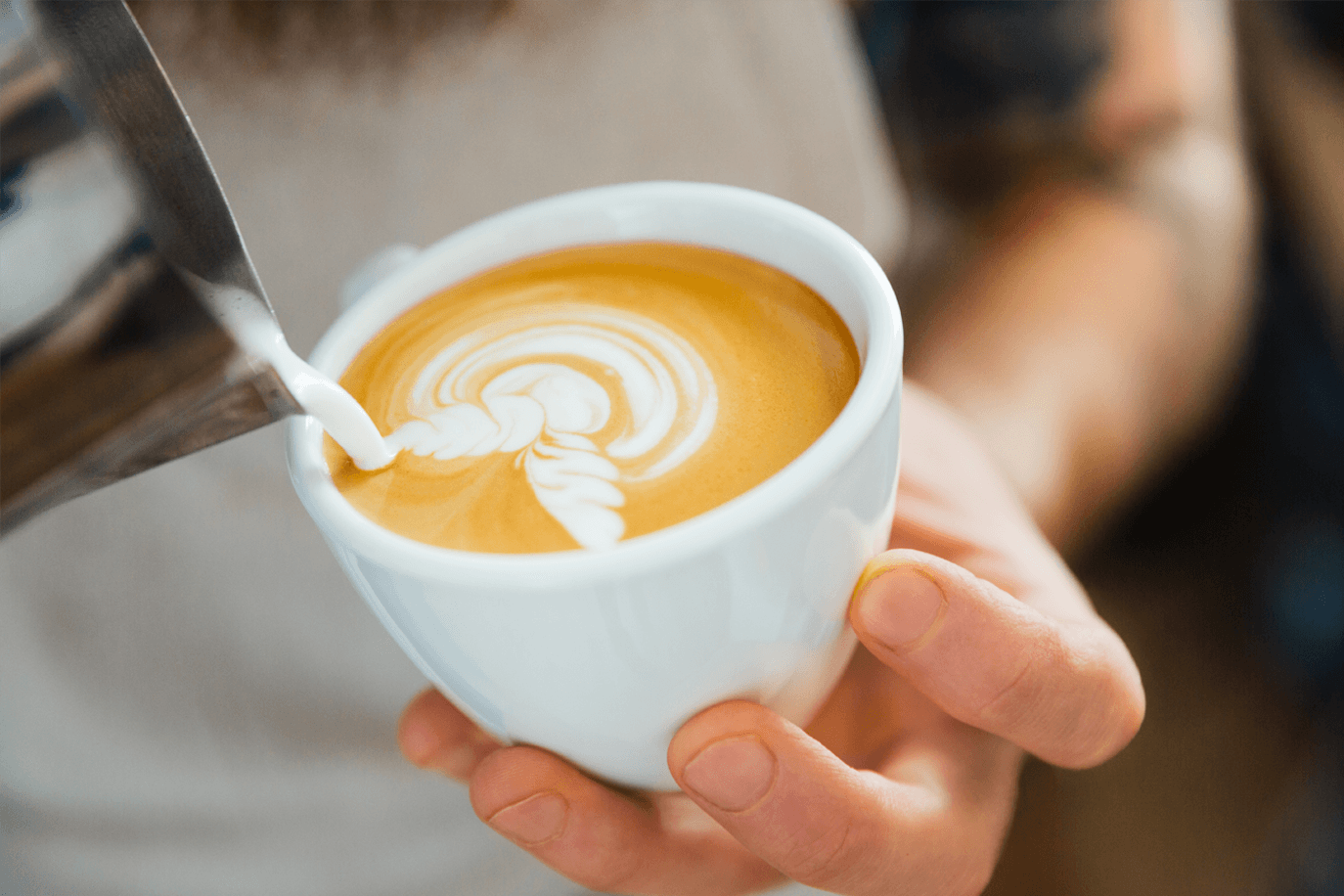 Latte art being poured by a barista